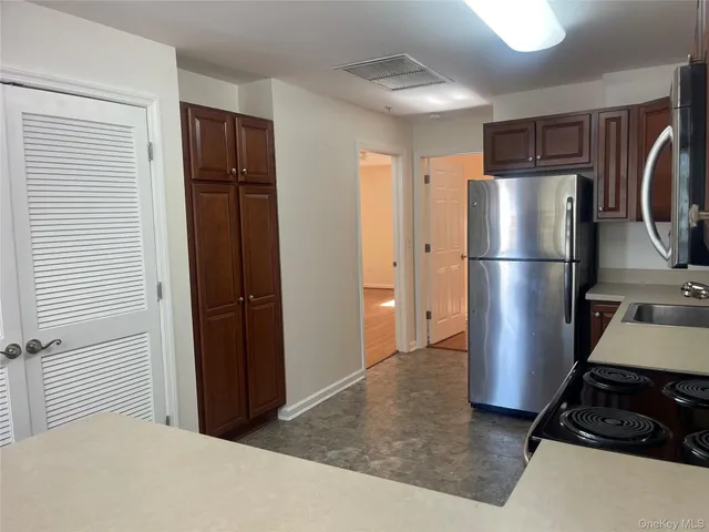a kitchen with stainless steel appliances granite countertop a refrigerator and a stove