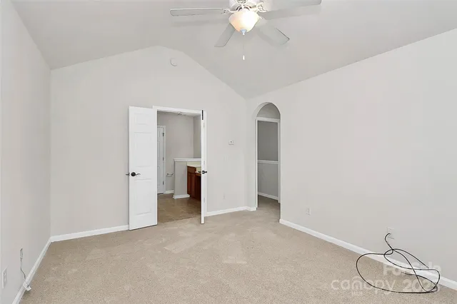 a view of an empty room with a chandelier fan