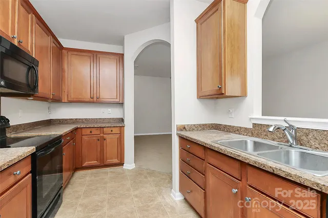 a kitchen with stainless steel appliances granite countertop a sink stove and microwave