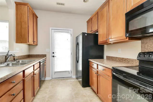 a kitchen with stainless steel appliances granite countertop a refrigerator stove and sink