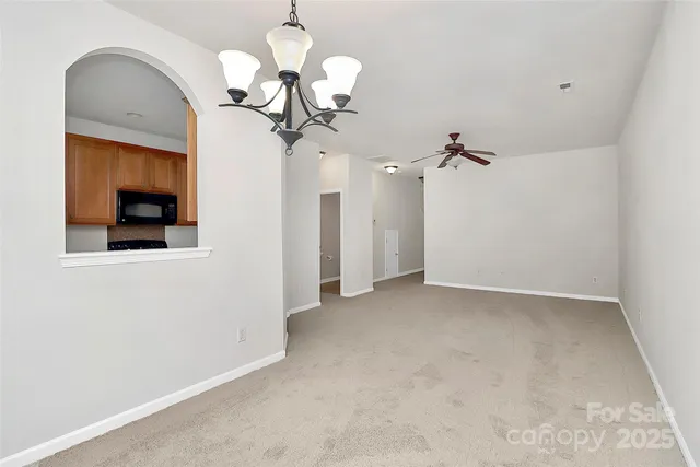 a view of a room with a chandelier fan