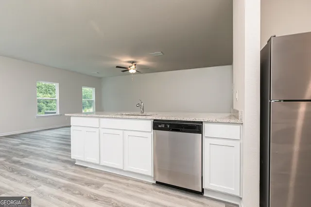 a kitchen with granite countertop white cabinets and white appliances