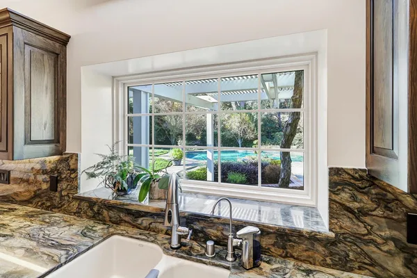 a bathroom with a granite countertop sink a toilet a mirror and shower