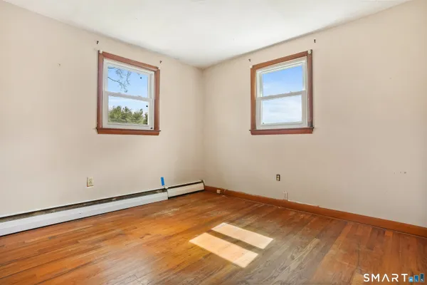 a view of a room with wooden floor and window