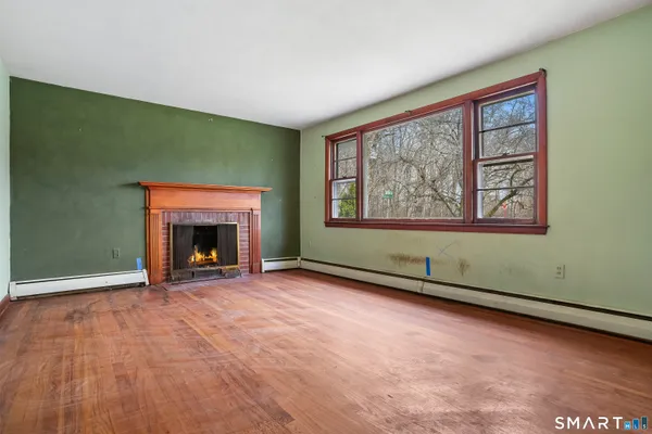 an empty room with windows fire place and a fireplace