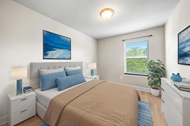 a bedroom with a large bed and a potted plant