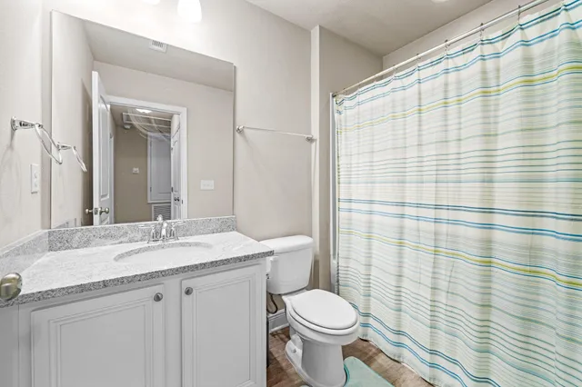 a bathroom with a granite countertop sink toilet and shower