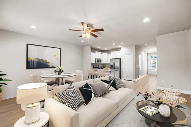 a living room with furniture and a view of kitchen