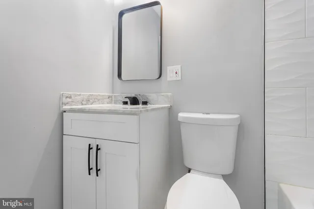 a bathroom with a toilet sink and mirror