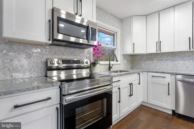 a kitchen with granite countertop a stove microwave and oven