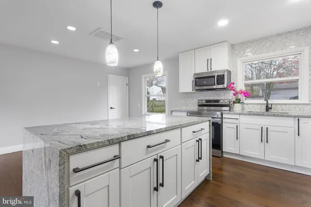 a kitchen with white cabinets and appliances
