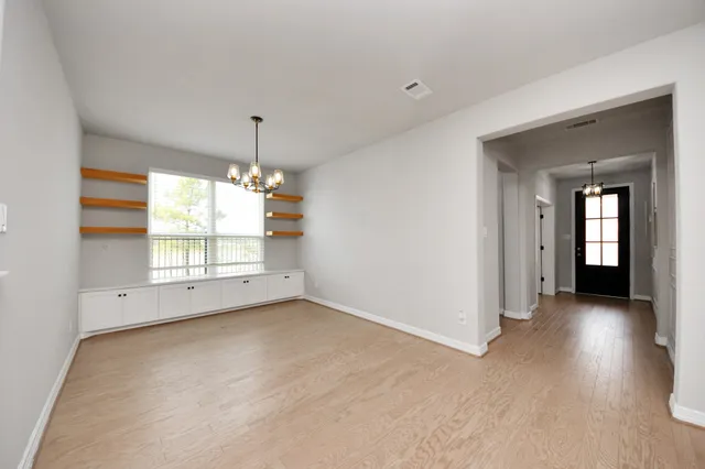 a view of a big room with chandelier fan and windows
