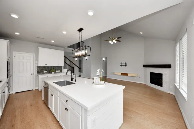 a large white kitchen with a sink and dishwasher with white walls