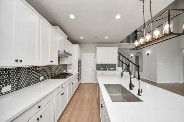 a kitchen with a stove a sink and a refrigerator