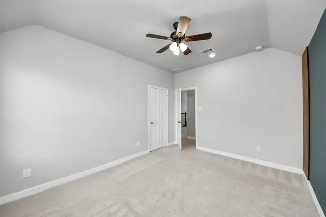 a view of empty room with window and ceiling fan