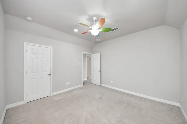 an empty room with a window and a fan