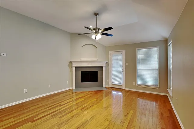 a view of an empty room with a window and a fireplace