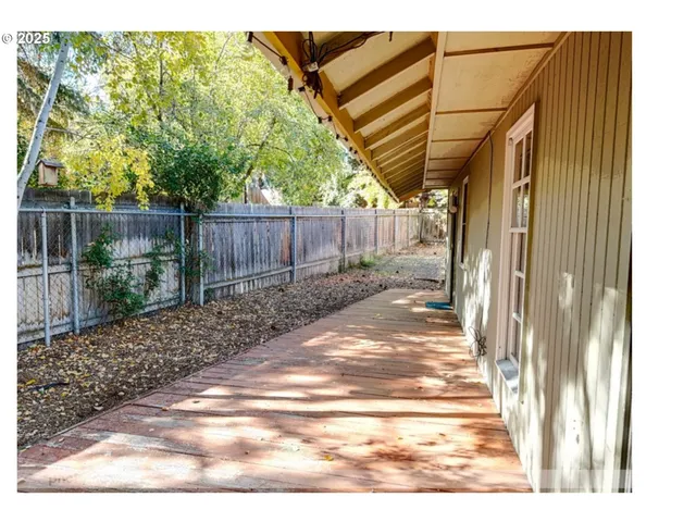 a view of a backyard with plants and wooden fence