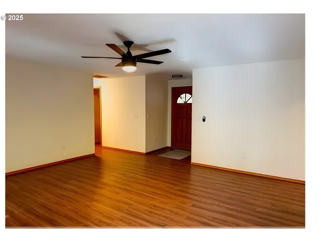 a view of an empty room with wooden floor