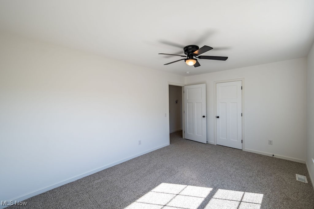 7343 Lost Pavement Road Belleville, WV 26133 - Photo 22 of 49 Unfurnished bedroom with light colored carpet, a closet, and a ceiling fan