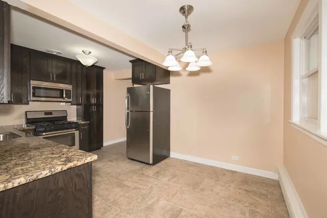a kitchen with stainless steel appliances granite countertop a refrigerator and a sink