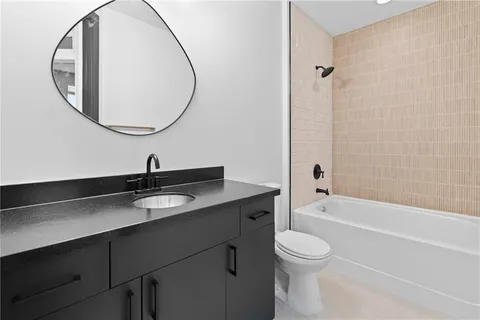 a bathroom with a granite countertop toilet a sink and a mirror