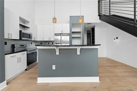 a kitchen with stainless steel appliances granite countertop a sink a stove and cabinets