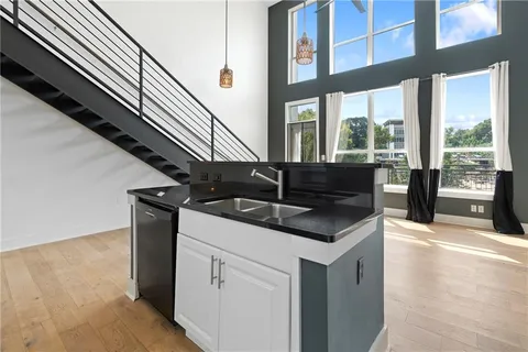 a kitchen with granite countertop a sink and a stove next to a window