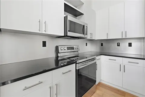 a kitchen with stainless steel appliances granite countertop white cabinets sink and dishwasher