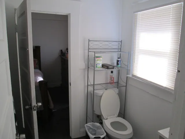 a white toilet sitting next to a window