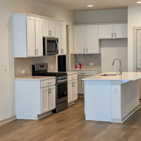 a kitchen with white cabinets stainless steel appliances and sink