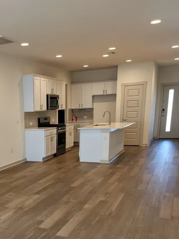 a large kitchen with a center island and a wooden floor