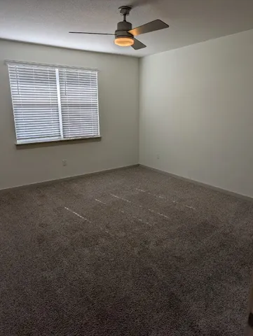 a view of kitchen with kitchen island granite countertop a stove top oven and white cabinets