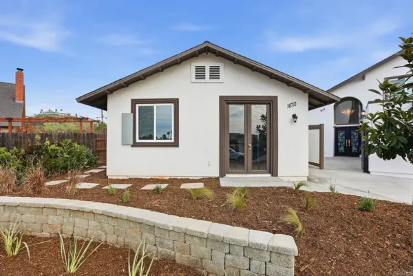 a kitchen with stainless steel appliances granite countertop a refrigerator a sink dishwasher a stove and white countertops with wooden floor