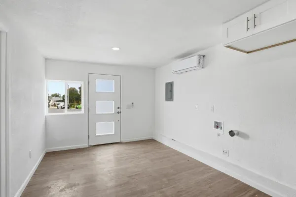 an empty room with wooden floor and windows