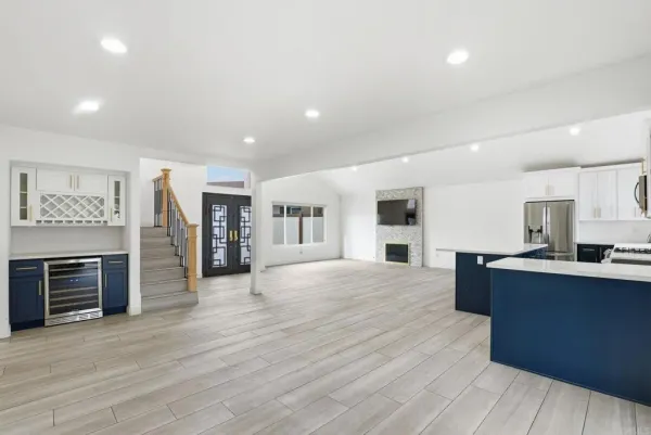 a large white kitchen with stainless steel appliances granite countertop a stove and cabinets