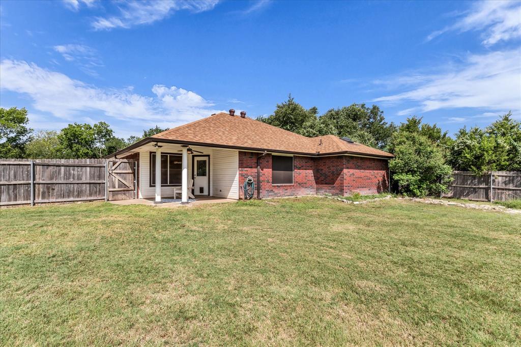 7 Market Loop Morgan's Point Resort, TX 76513 - Photo 25 of 31 Expansive backyard featuring a covered patio, brick exterior, wood fence, and mature perimeter trees