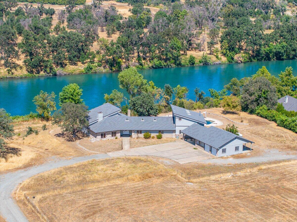 an aerial view of a house with a yard and lake view