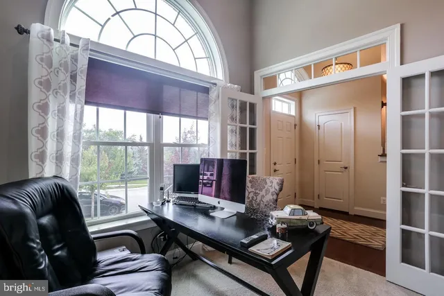 a living room with furniture and floor to ceiling windows