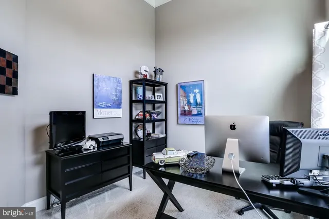 a view of a workspace with furniture and a window
