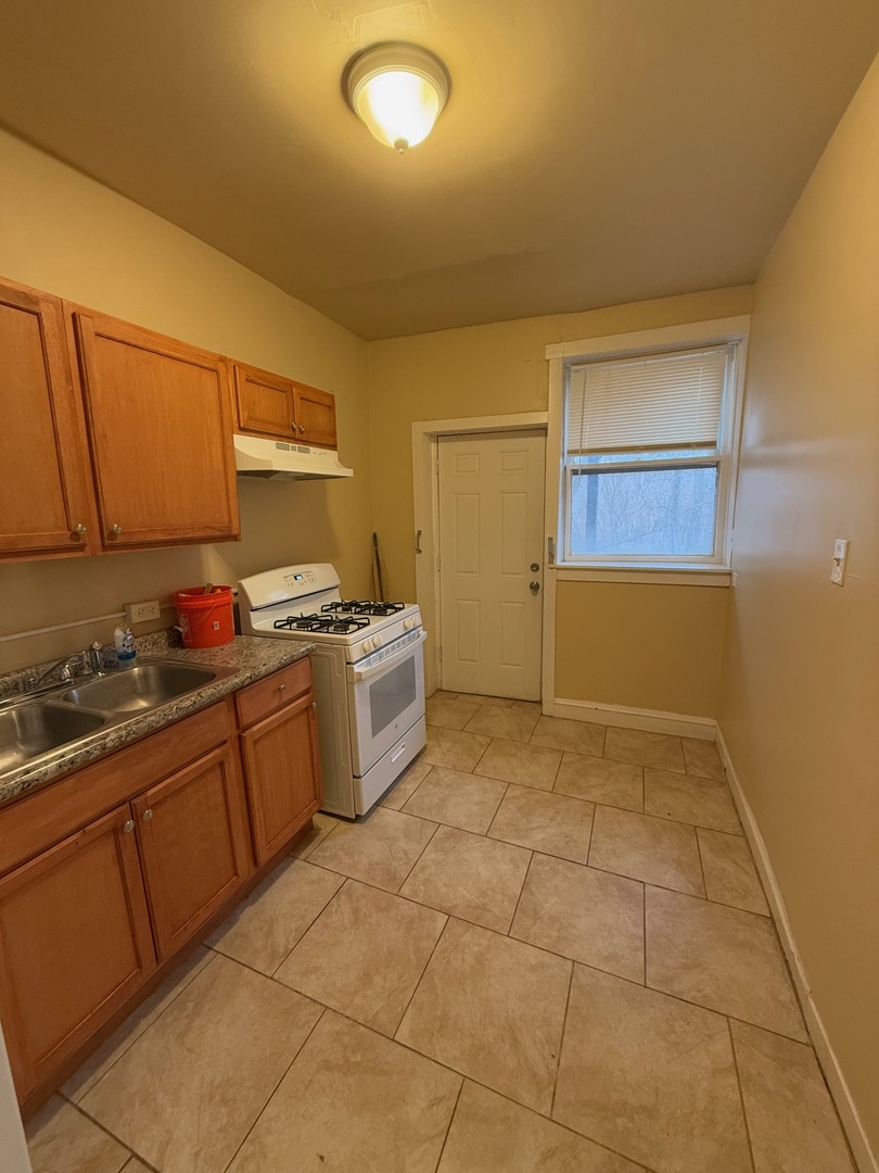 715 West 57th Street, Unit 2 Chicago, IL 60621 - Photo 6 of 12 a kitchen with a sink a stove cabinets and utility room