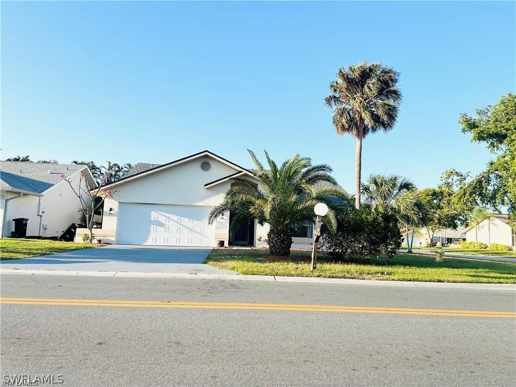 a palm tree sitting in front of a house with a yard