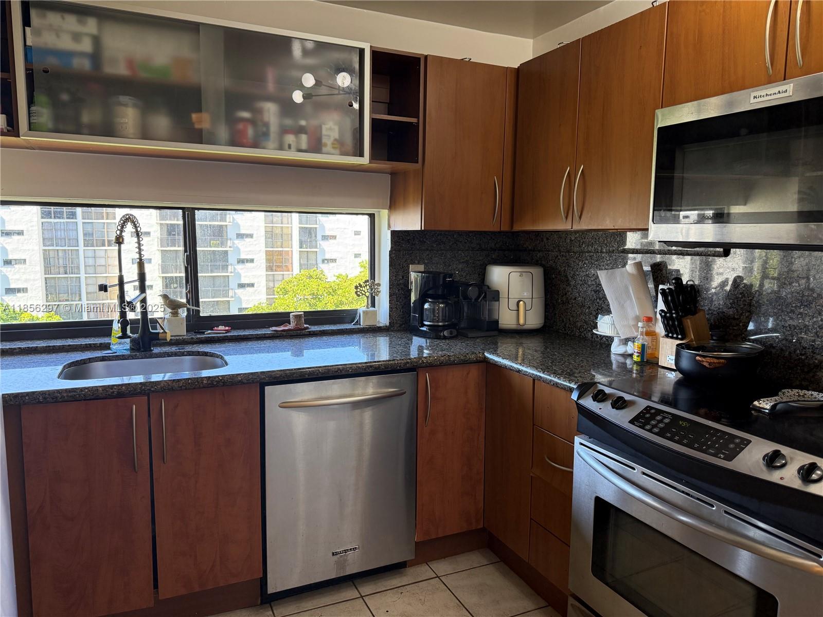 16919 North Bay Road, Unit 710 Sunny Isles Beach, FL 33160 - Photo 2 of 7 a kitchen with stainless steel appliances a stove microwave and sink