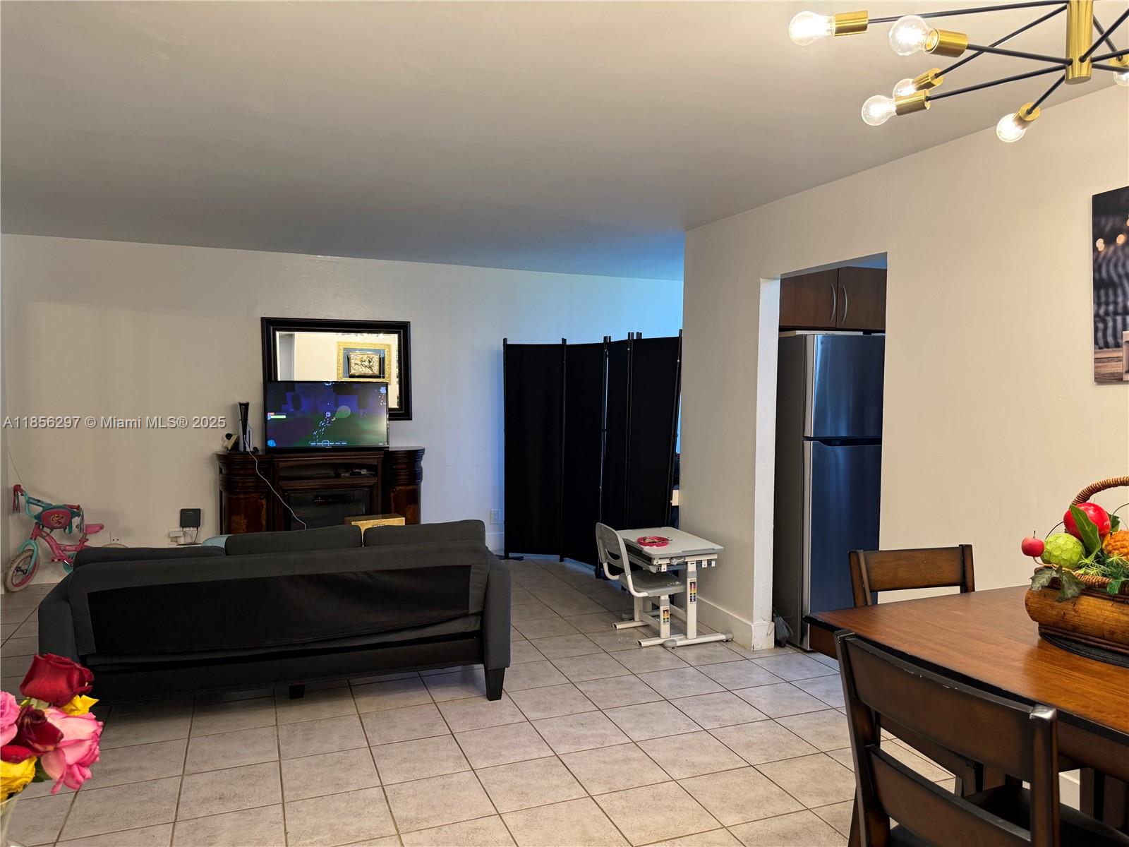 16919 North Bay Road, Unit 710 Sunny Isles Beach, FL 33160 - Photo 3 of 7 a living room with furniture a flat screen tv and a window