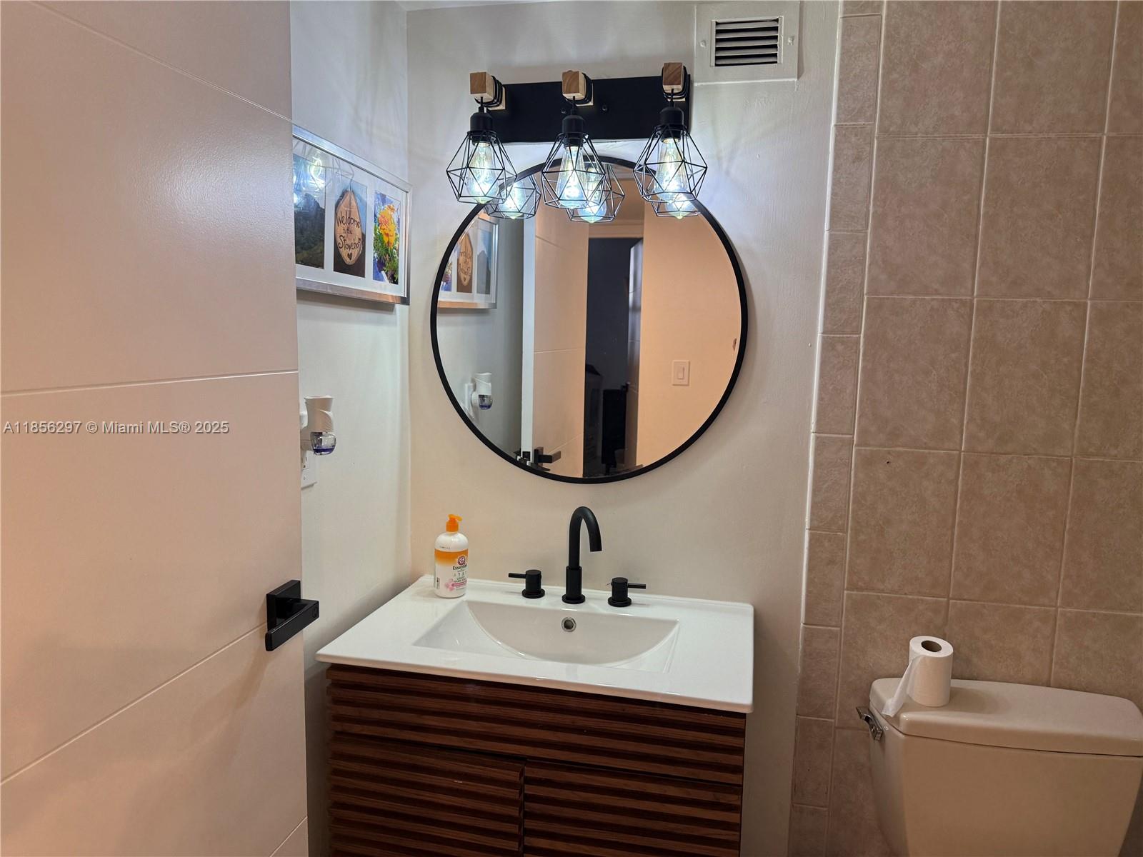 16919 North Bay Road, Unit 710 Sunny Isles Beach, FL 33160 - Photo 4 of 7 a bathroom with a sink and a mirror