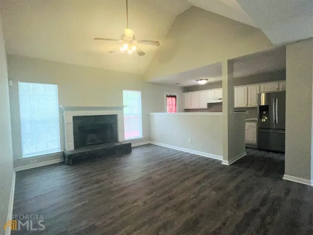 a view of a kitchen with a sink a refrigerator and a fireplace
