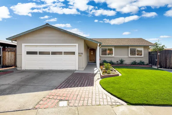 a view of a house with a yard patio and a garden