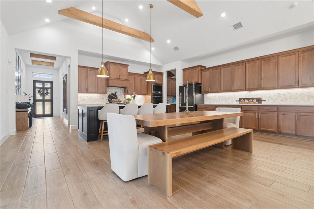 582 Broadleaf Way Haslet, TX 76052 - Photo 5 of 40 Custom lighting throughout the home. Stained wood beams in kitchen, dining and main living area. Beautiful wood flooring. So much counterspace for food prep and entertaining.
