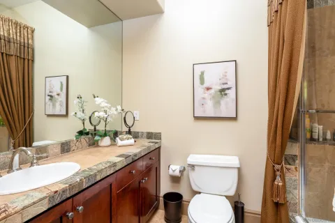 a bathroom with a granite countertop sink a toilet and a mirror