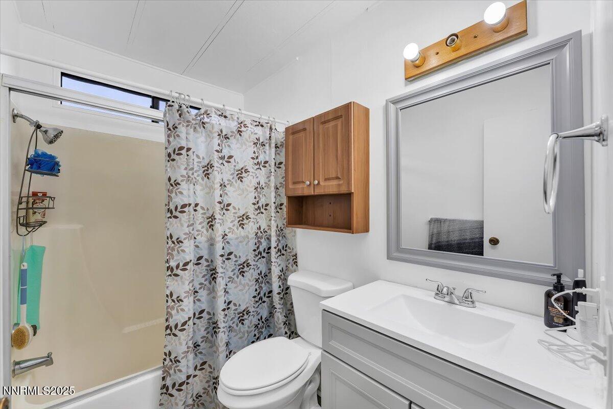 485 Capricorn Circle Reno, NV 89521 - Photo 25 of 31 a bathroom with a sink a toilet and shower curtain